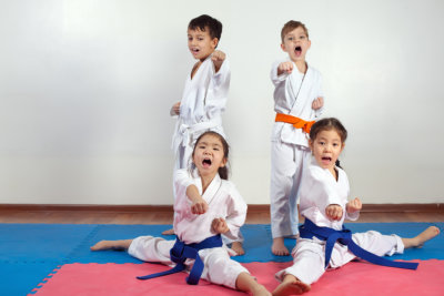 Four children demonstrate martial arts working together.