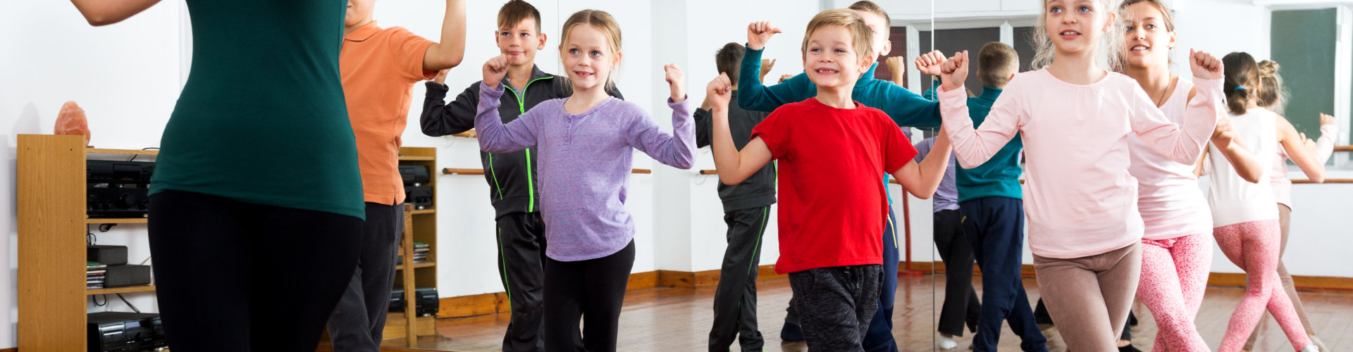 Happy little children studying modern style dance in class